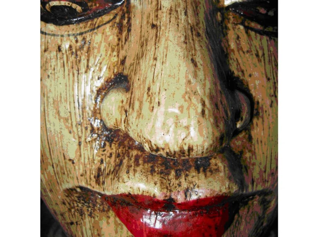 A close up of the face of a wooden mask